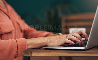 Buy stock photo Cropped shot of an unrecognisable woman typing on a laptop inside of a coffee shop during the day