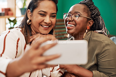 Buy stock photo Shot of two young women taking selfies at cafe