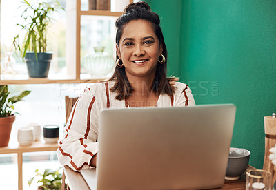 Buy stock photo Shot of a young woman using a laptop at a cafe