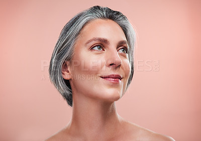 Buy stock photo Studio shot of a beautiful mature woman posing against a peach background