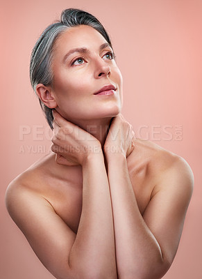 Buy stock photo Studio shot of a beautiful mature woman posing against a peach background