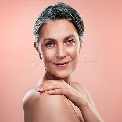 Buy stock photo Studio portrait of a beautiful mature woman posing against a peach background