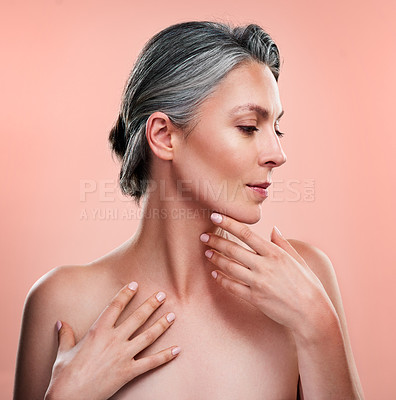 Buy stock photo Studio shot of a beautiful mature woman posing against a peach background
