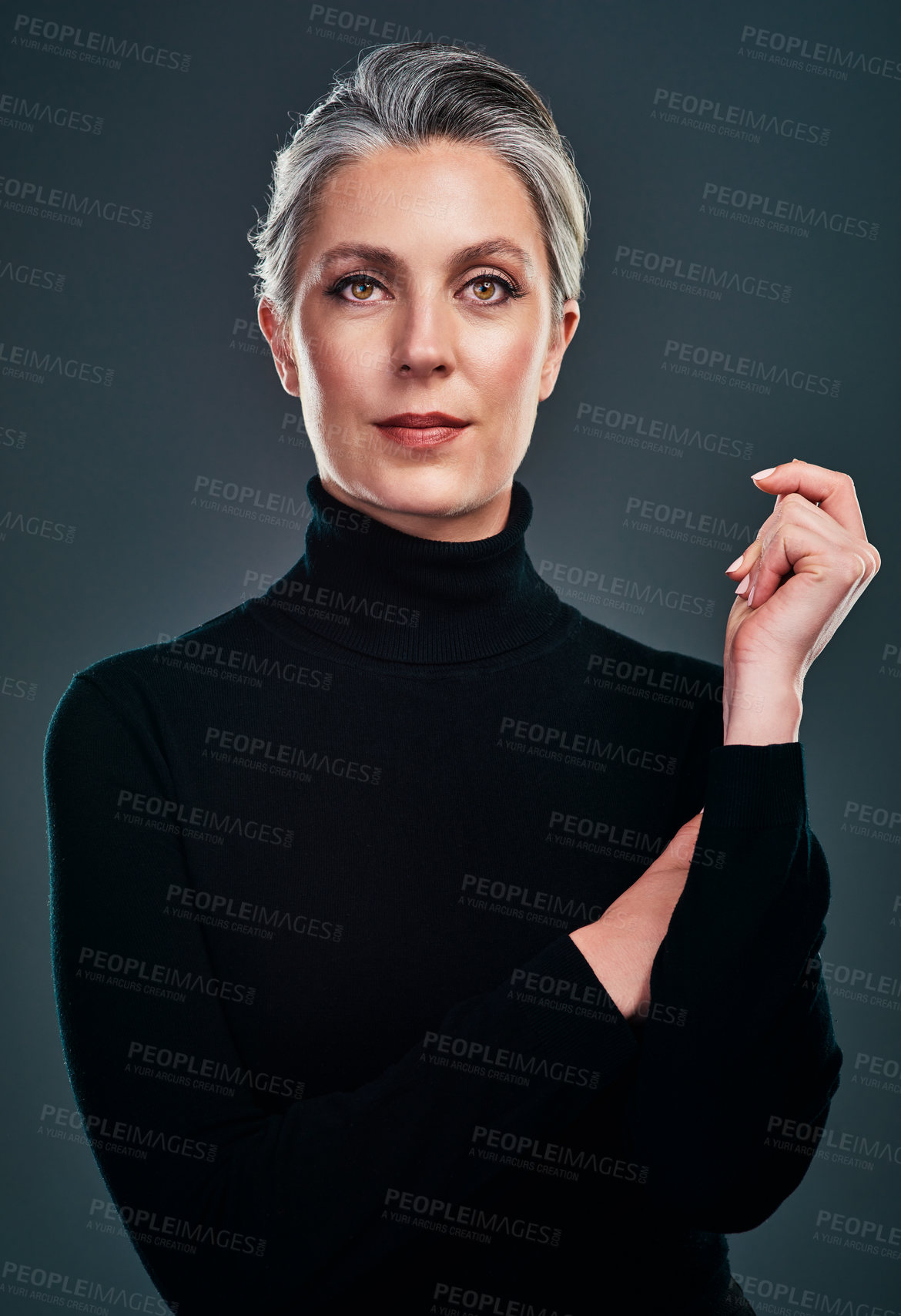 Buy stock photo Studio portrait of a beautiful mature woman posing against a dark background