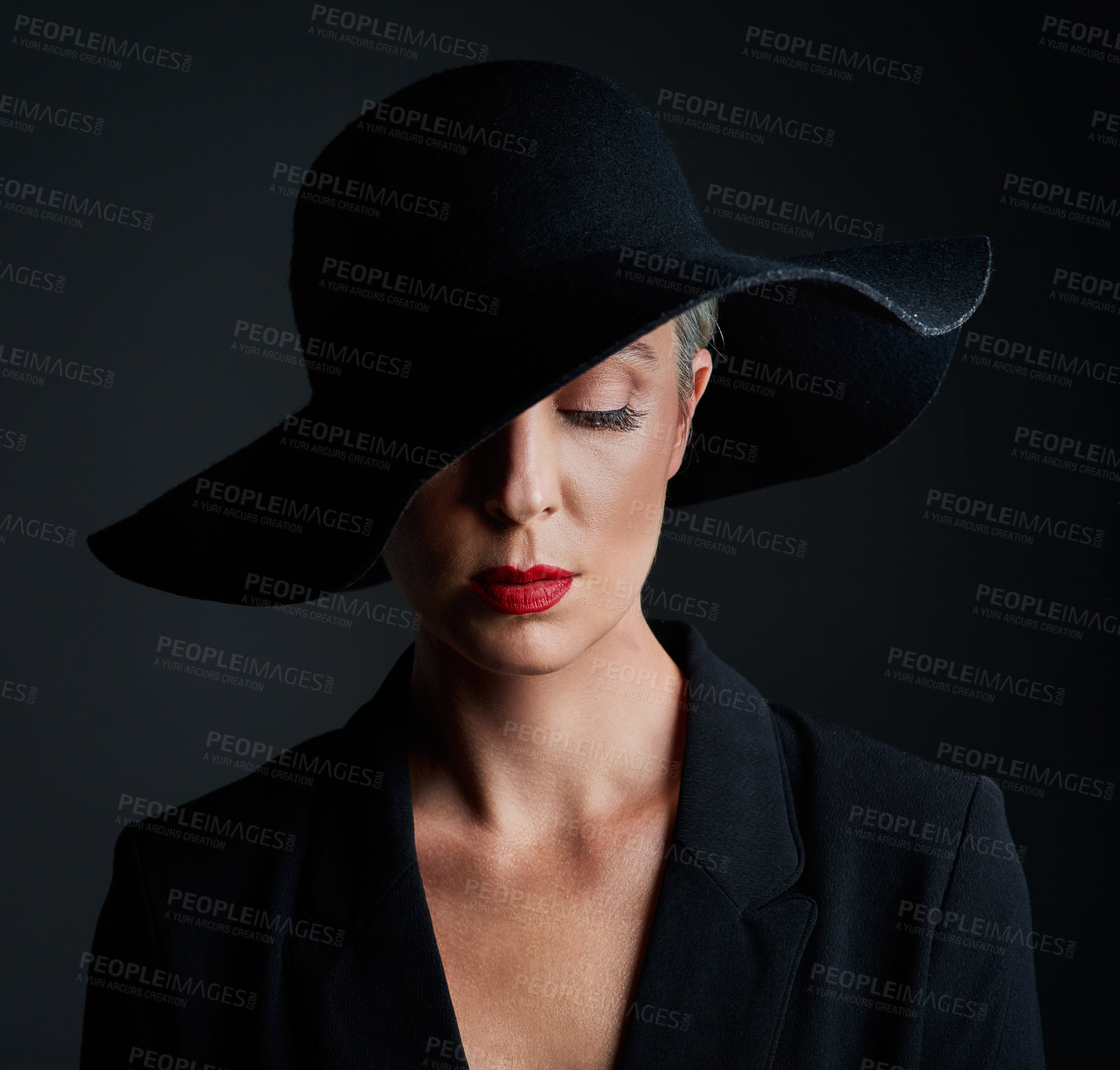 Buy stock photo Mature woman, elegance and hat for fashion with classy clothes, unique luxury and designer brand in studio. Senior lady, makeup and style inspiration for magazine cover or runway by black background