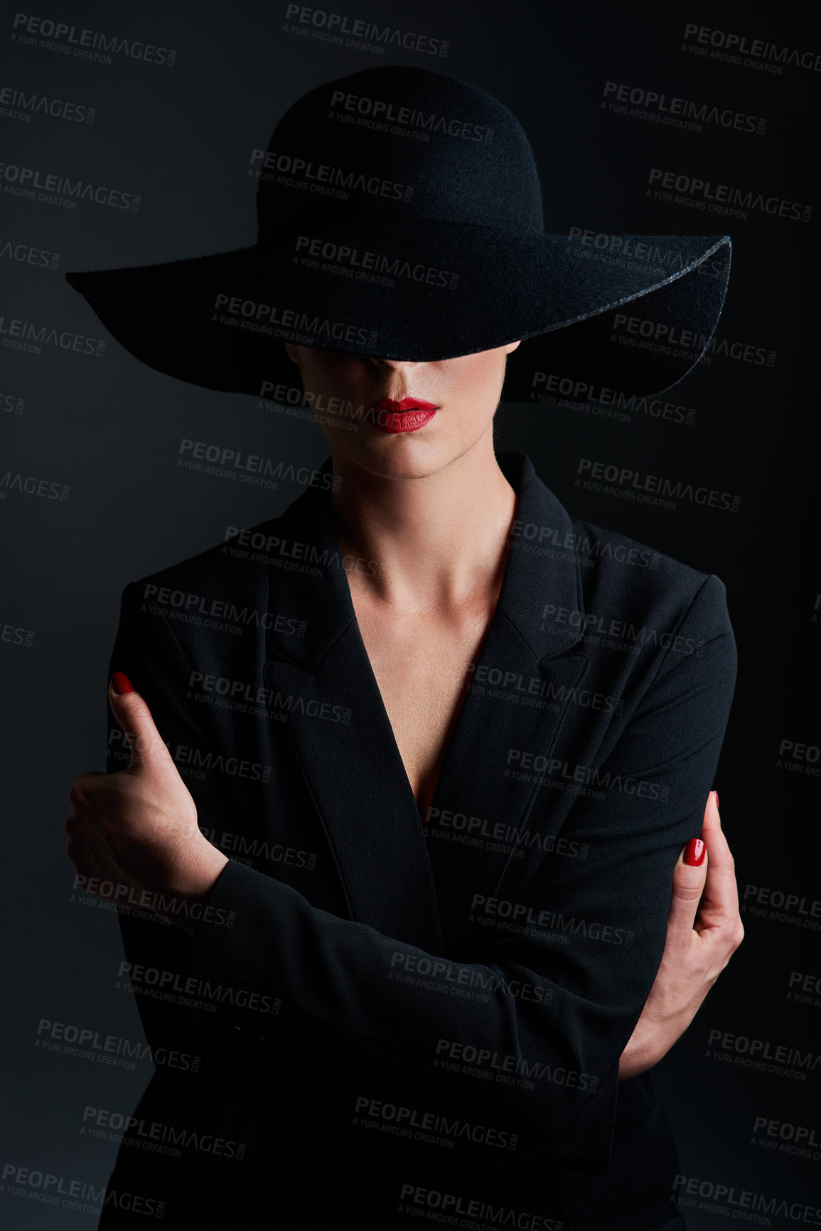 Buy stock photo Studio shot of a beautiful mature woman wearing a hat and posing against a dark background