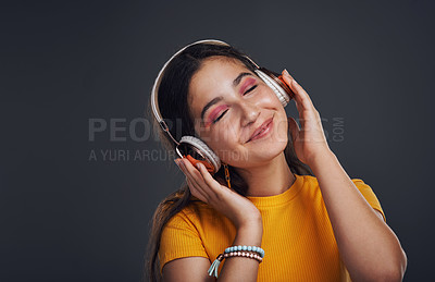 Buy stock photo Girl, headphones and music in studio to relax, smile and streaming online on gray background. Female person, mockup space and playlist for audio connection, listening and subscription for podcast