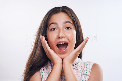 Buy stock photo Cropped portrait of an attractive teenage girl standing alone against a white studio background with her hands to her face