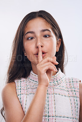 Buy stock photo Cropped shot of an attractive teenage girl standing with her finger on her lips against a white studio background