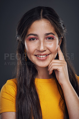Buy stock photo Cropped portrait of an attractive teenage girl standing alone against a dark background in the studio