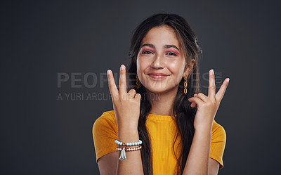 Buy stock photo Cropped portrait of an attractive teenage girl standing alone and feeling playful against a dark background in the studio