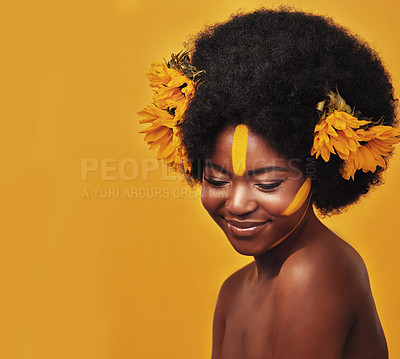 Buy stock photo Studio shot of a beautiful young woman posing topless with sunflowers in her hair against a mustard background