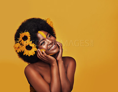 Buy stock photo Black person, skincare and sunflower in studio with plant for natural glow, dermatology or vitamin e. Woman, smile and mockup with thinking for organic, cosmetics and soft skin on yellow background