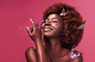 Buy stock photo Studio shot of a beautiful young woman smiling while posing with butterflies in her hair against a purple background