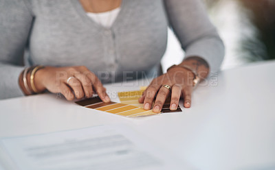Buy stock photo Cropped shot of an unrecognizable businesswoman sitting alone in her office and looking at a colour swatch