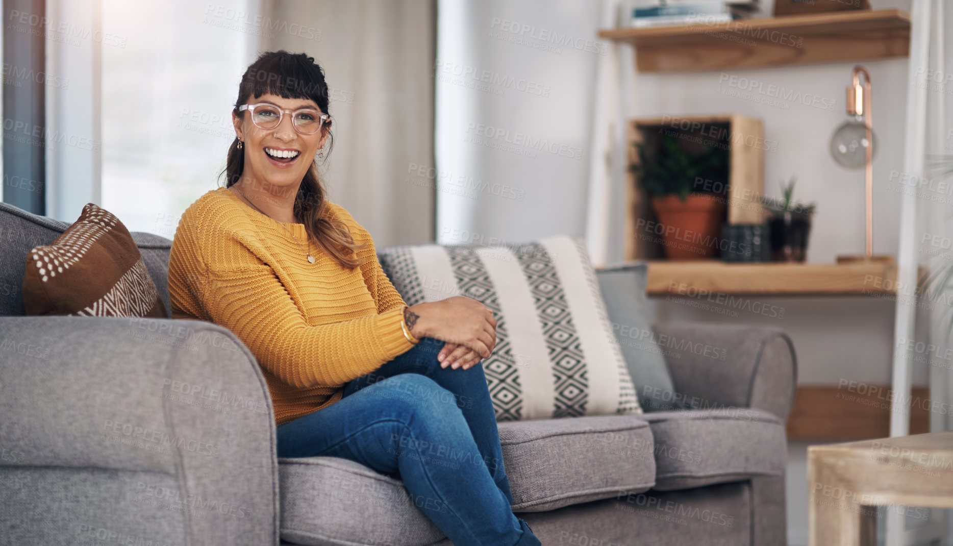 Buy stock photo Cropped portrait of an attractive young woman sitting alone in her living room during a day off