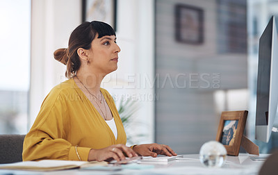 Buy stock photo Cropped shot of an attractive young businesswoman sitting alone in her office and using her computer