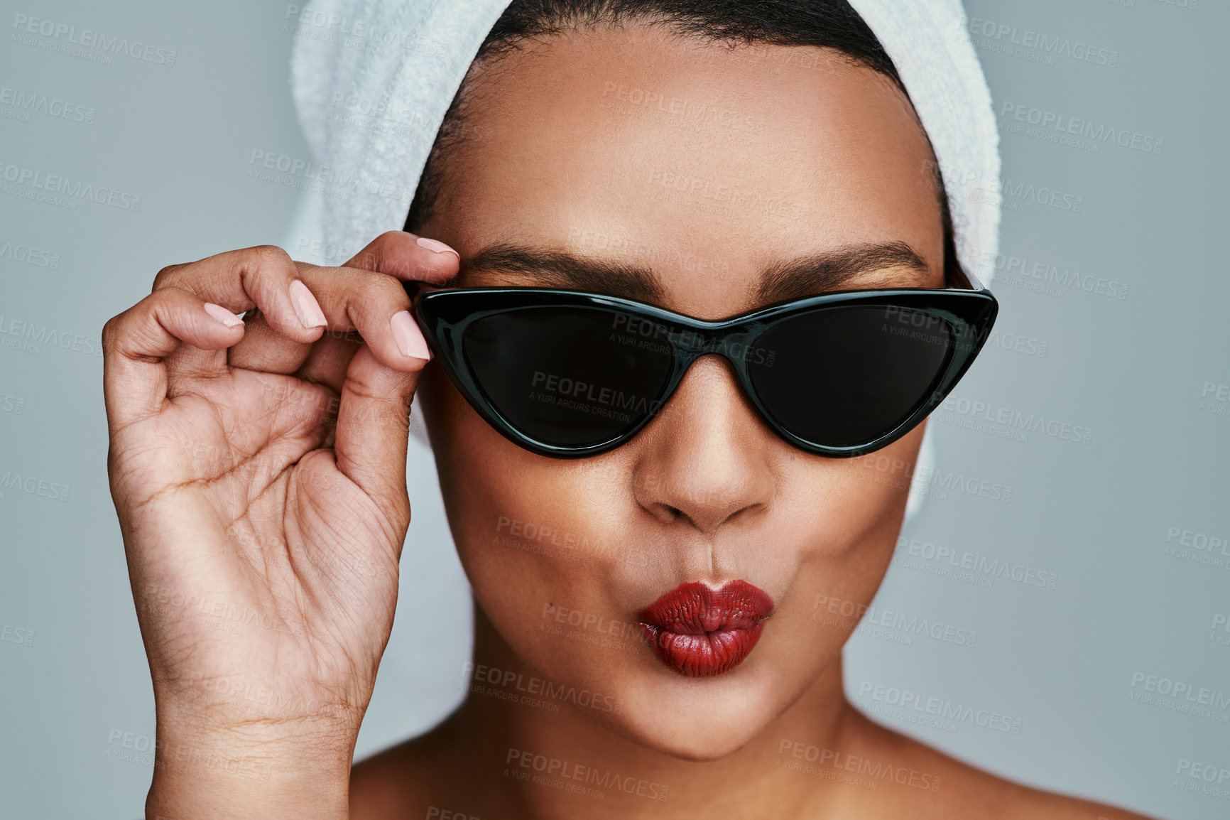 Buy stock photo Cropped shot of a beautiful young woman posing with sunglasses and red lipstick