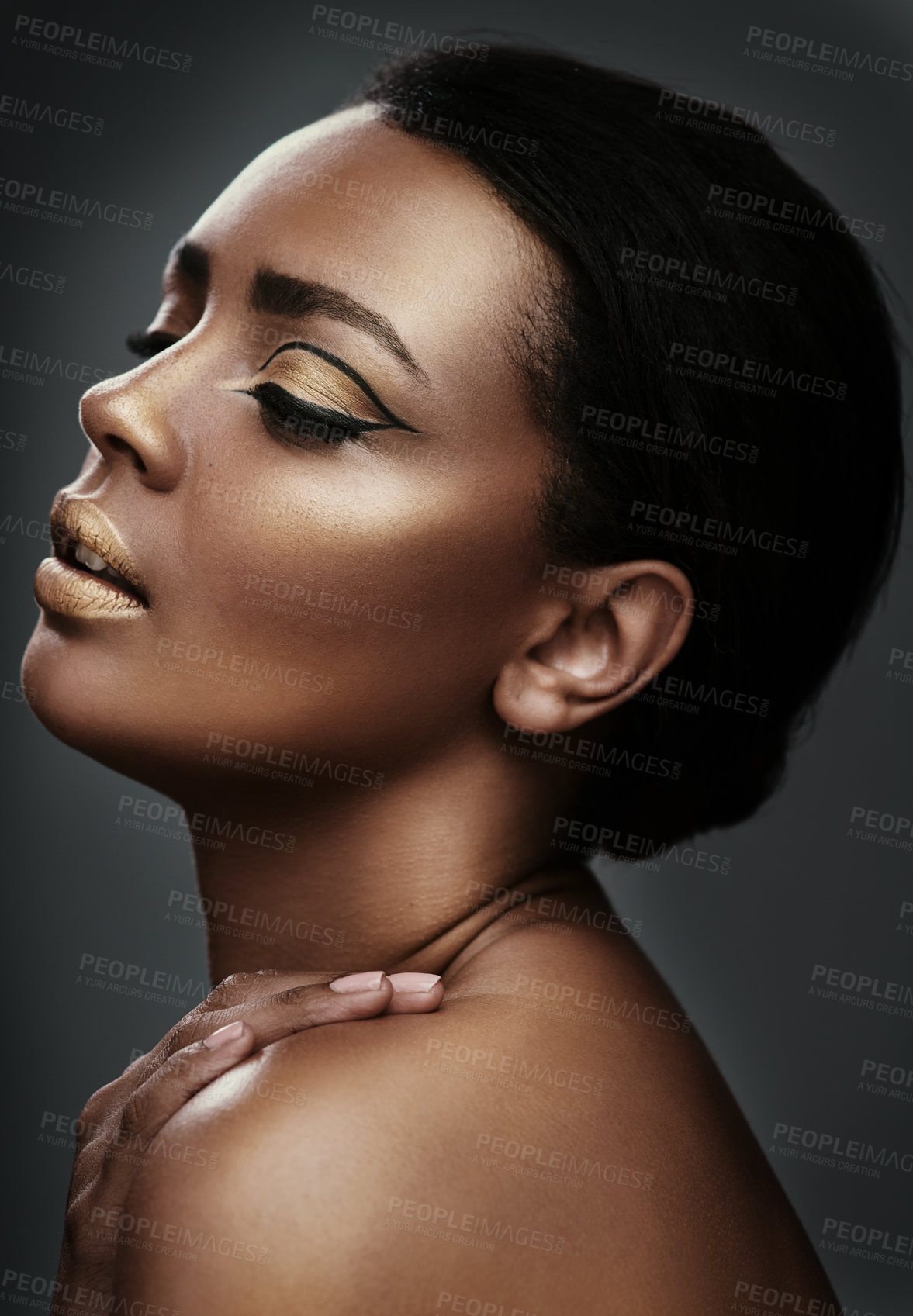 Buy stock photo Cropped shot of a beautiful young woman wearing gold makeup against a grey background