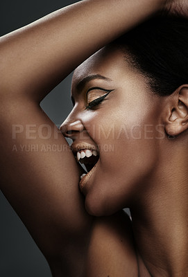 Buy stock photo Shot of a beautiful young woman biting into her arm
