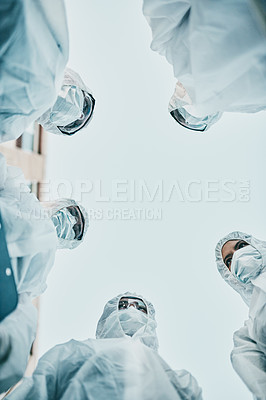 Buy stock photo Safe, secure and covered group of healthcare workers wearing masks and hazmat suits. Low angle of covid safety hygiene staff working together during an outbreak in the city to stop the disease spread