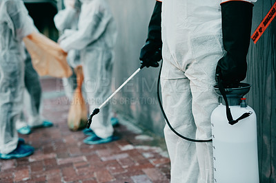 Buy stock photo Healthcare workers, cleaning and working to prevent an outbreak of covid. Medical worker in sterile uniform, holding disinfectant and sterilizing. People in protective suits disinfecting the area.