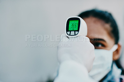 Buy stock photo Shot of a young woman getting her temperature taken with an infrared thermometer by a healthcare worker during an outbreak