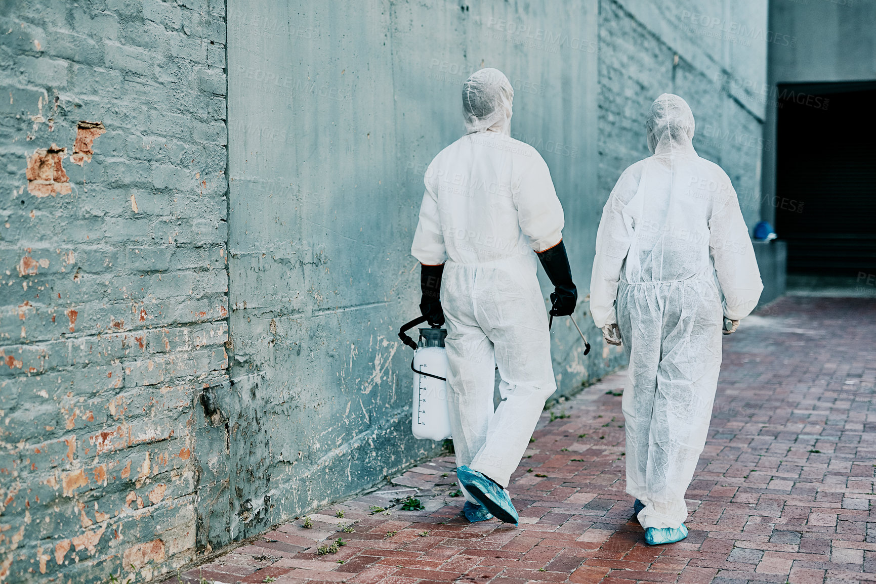 Buy stock photo Healthcare workers wearing protective hazmat suits to help prevent the spread of a toxic infection or covid pandemic. First responders cleaning a building for better hygiene and safety