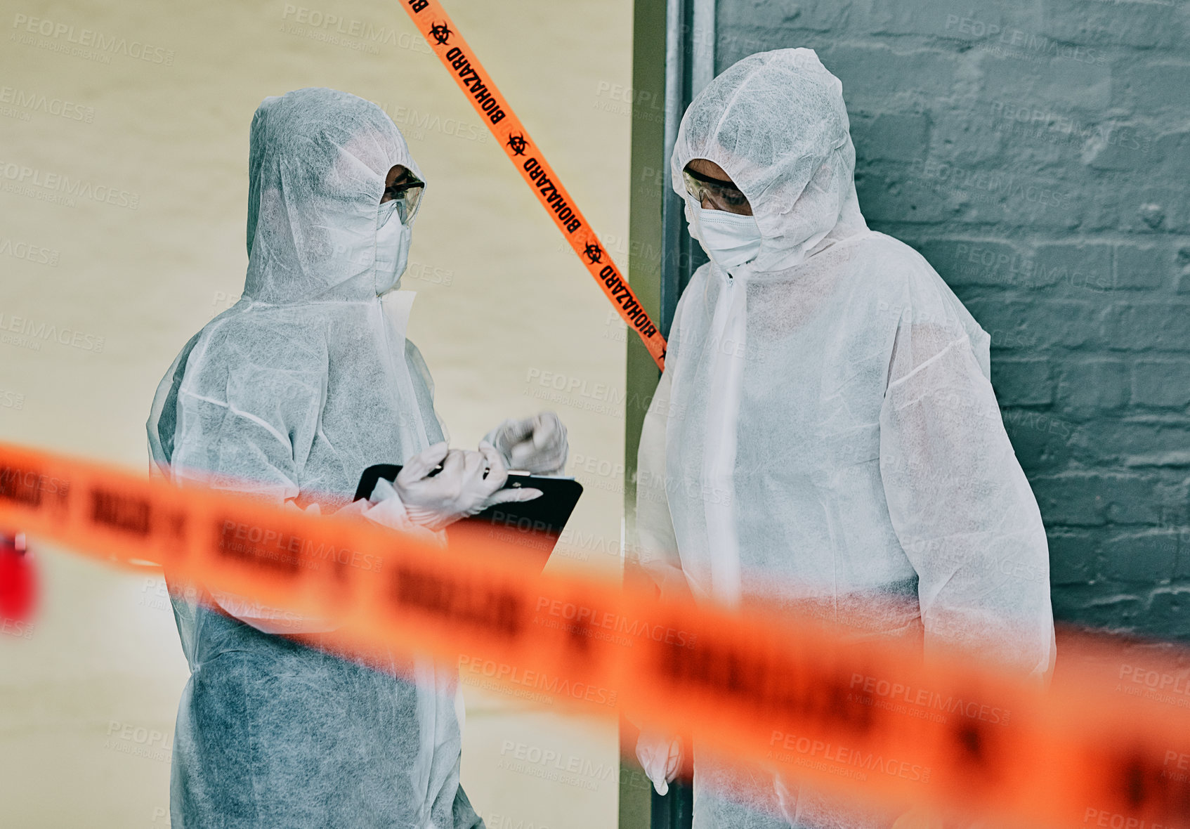 Buy stock photo Forensic investigators collecting evidence at a murder scene in a building with barrier tape. Criminal researchers investigating a crime site and talking about the incident or case