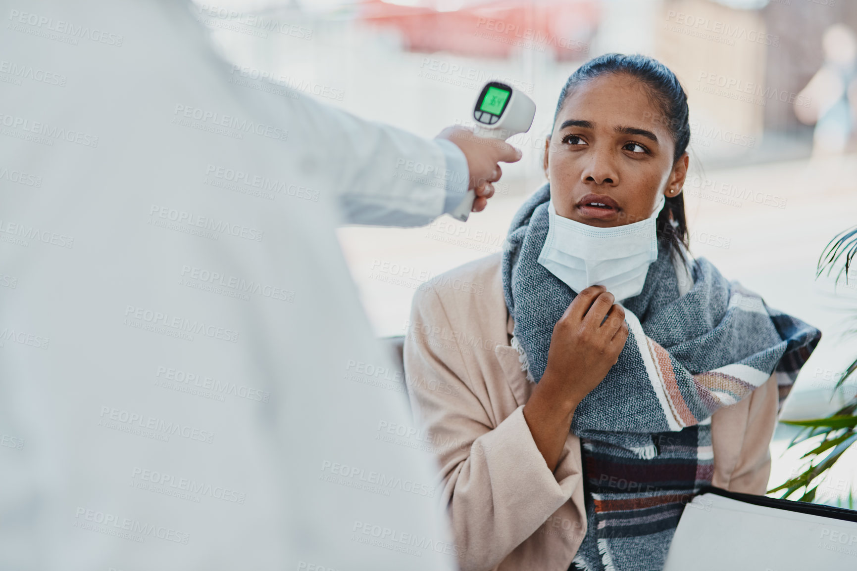 Buy stock photo Covid temperature scanning a woman head at the border or an airport with real scared, concerned and serious expression on her face. Traveling refugee or foreign lady with a face mask in quarantine