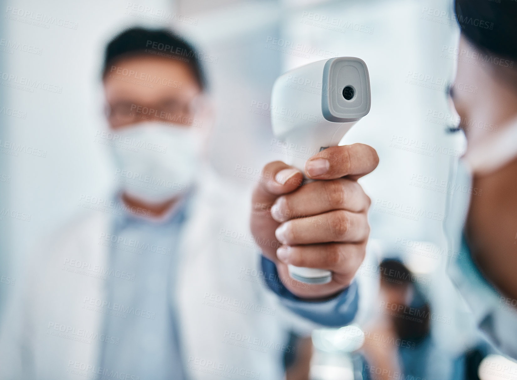 Buy stock photo Shot of a young woman getting her temperature taken with an infrared thermometer by a healthcare worker during an outbreak