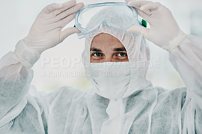 Buy stock photo Shot of a young man putting on his protective gear before the decontamination process