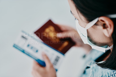 Buy stock photo A woman traveling during the covid pandemic holding her passport and flight ticket at the airport. A tourist leaving the country due to the ease of travel restrictions during the coronavirus pandemic