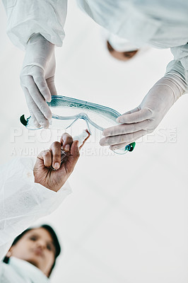 Buy stock photo Cropped shot of two healthcare workers disinfecting themselves with hand sanitiser