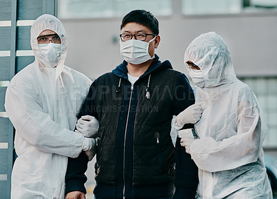 Buy stock photo Shot of a young man getting taken away by healthcare workers in hazmat suits during an outbreak