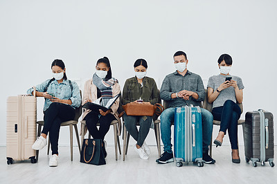 Buy stock photo Shot of a group of young people wearing masks while waiting together in an airport lounge