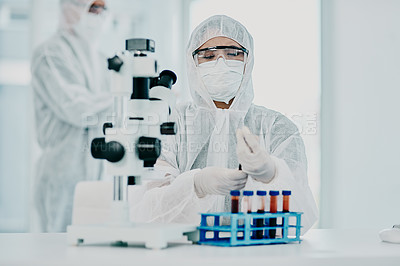 Buy stock photo A scientist conducting a medical experiment to research covid vaccine in a lab and collecting blood samples. Healthcare researcher analyzing chemicals in a chemistry laboratory wearing a hazmat suit