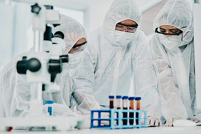 Buy stock photo Shot of a group of scientists in hazmat suits conducting medical research in a laboratory