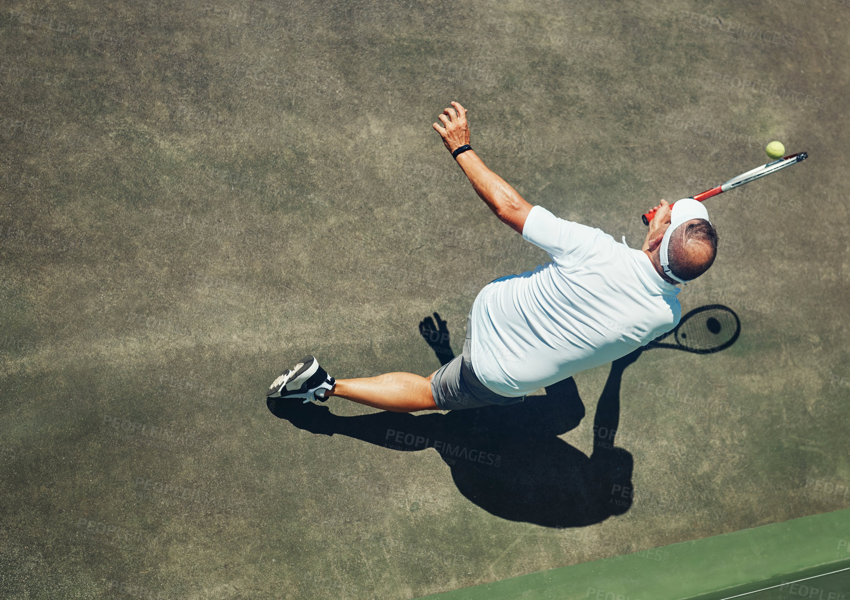 Buy stock photo High angle shot of a focused middle aged man playing tennis outside on a tennis court during the day