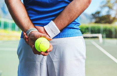Buy stock photo Rearview shot of an unrecognizable male tennis player holding a tennis ball on a court outdoors