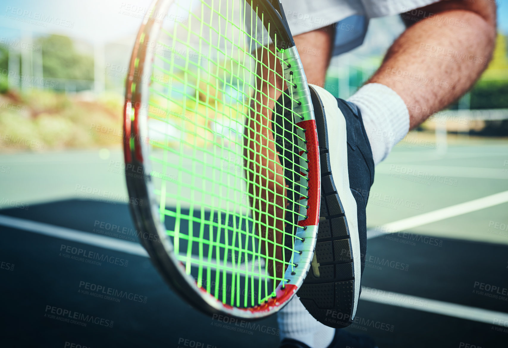 Buy stock photo Cropped shot of an unrecognizable male tennis player kicking his tennis racket outdoors on a tennis court