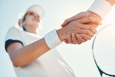 Buy stock photo Cropped shot of an attractive young female tennis player shaking hands with an opponent outdoors on the court