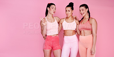 Buy stock photo Studio portrait of a group of sporty young women making faces while standing together against a pink background