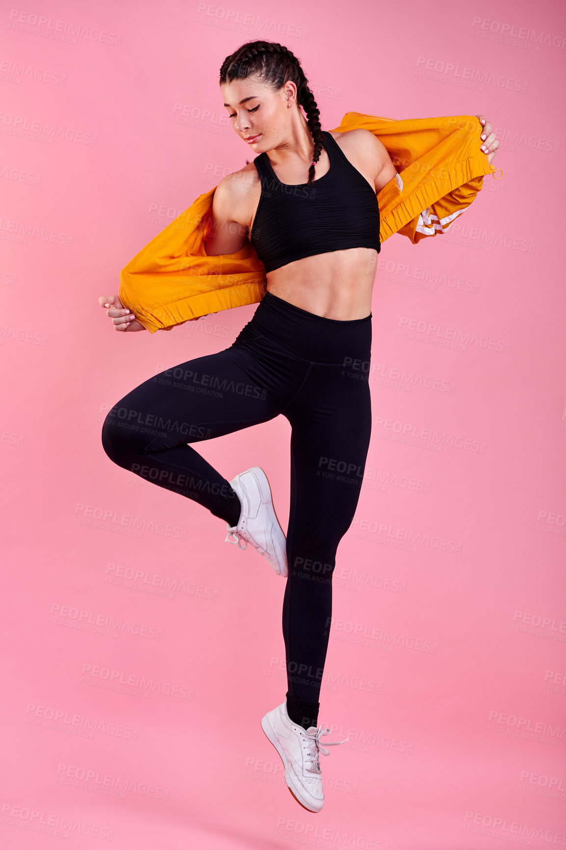 Buy stock photo Fitness, jumping and girl in studio for dancing, cool fashion and exercise challenge. Trendy clothes, creative workout and gen z woman on pink background for training, performance or sports athlete