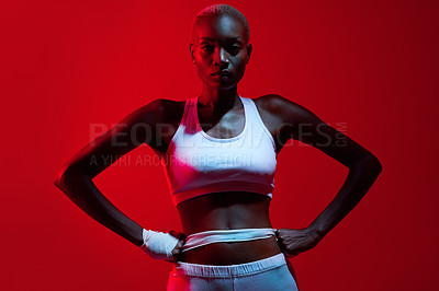 Buy stock photo Red filtered shot of a female boxer posing with her fists on her hips