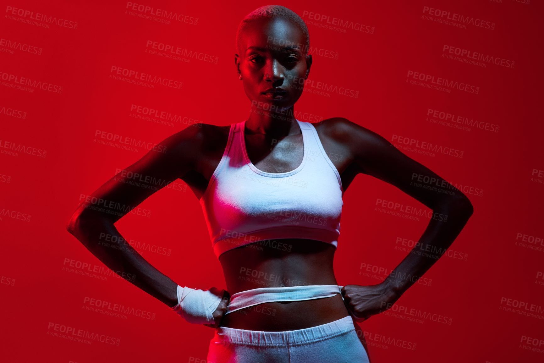 Buy stock photo Red filtered shot of a female boxer posing with her fists on her hips