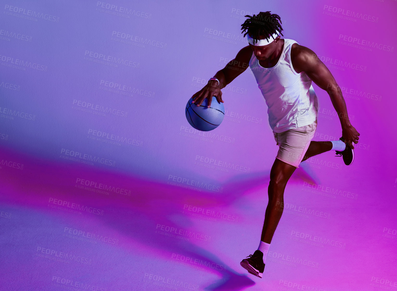 Buy stock photo Purple filtered shot of a sporty young man playing basketball