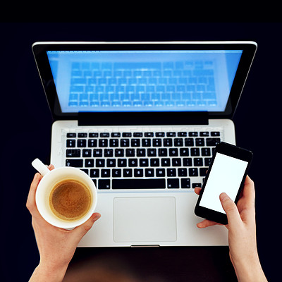 Buy stock photo High angle shot of an unidentifiable woman using her phone and laptop while drinking a cup of coffee