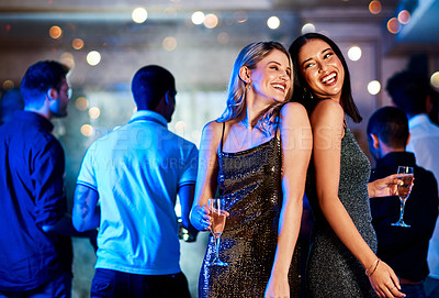 Buy stock photo Cropped shot of two cheerful young women having drinks while dancing on the dance floor of a club at night