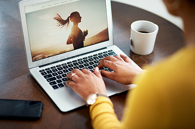 Buy stock photo Cropped shot of an unrecognizable woman sitting alone in her home and using her laptop